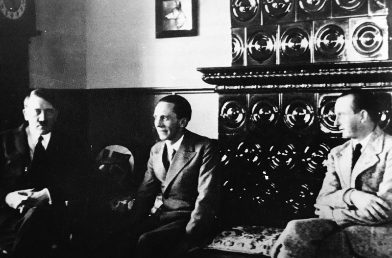 Adolf Hitler, Joseph Goebbel and Otto Dietrich sit near a Kachelofen (a typical German tile covered stove) in Haus Wachenfeld